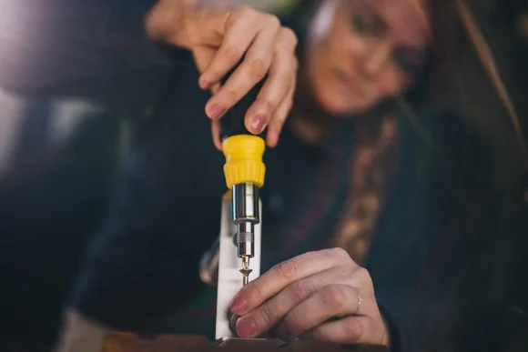 Person schraubt Holzlatten zusammen